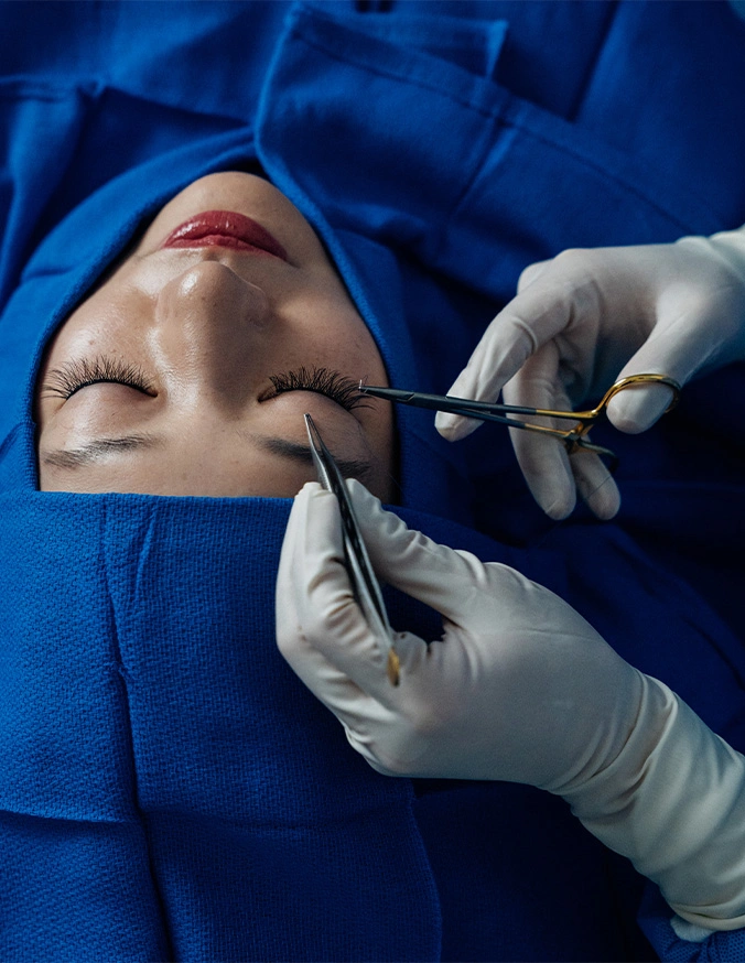 Harry Ching MD performing facial plastic surgery procedure on patient draped in blue surgical cloth - Asian Eyelid Surgery in Las Vegas, NV