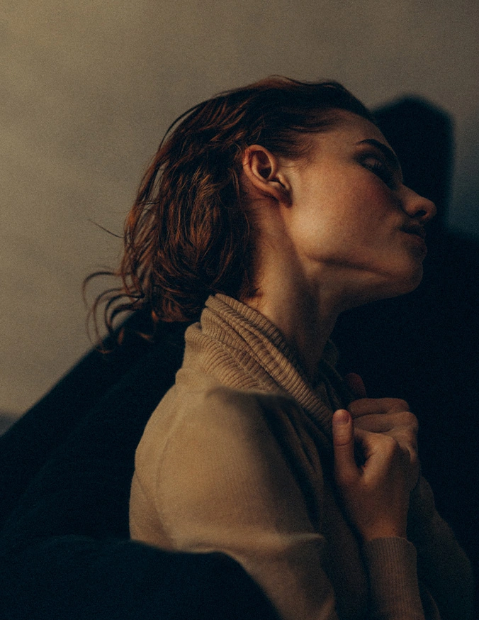 Woman in profile wearing cream turtleneck sweater with dramatic shadow lighting against neutral background - Neck Lift in Las Vegas, NV